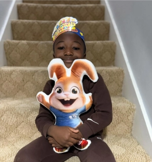 boy sitting on stairs and holding bunny